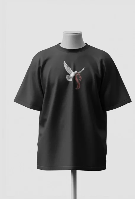 Small white dove trailing a red scarf printed on the chest of a black oversized t-shirt