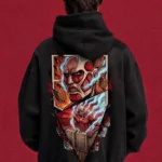 Model wearing a black Attack on Titan hoodie, back view with colourful Colossal Titan collage